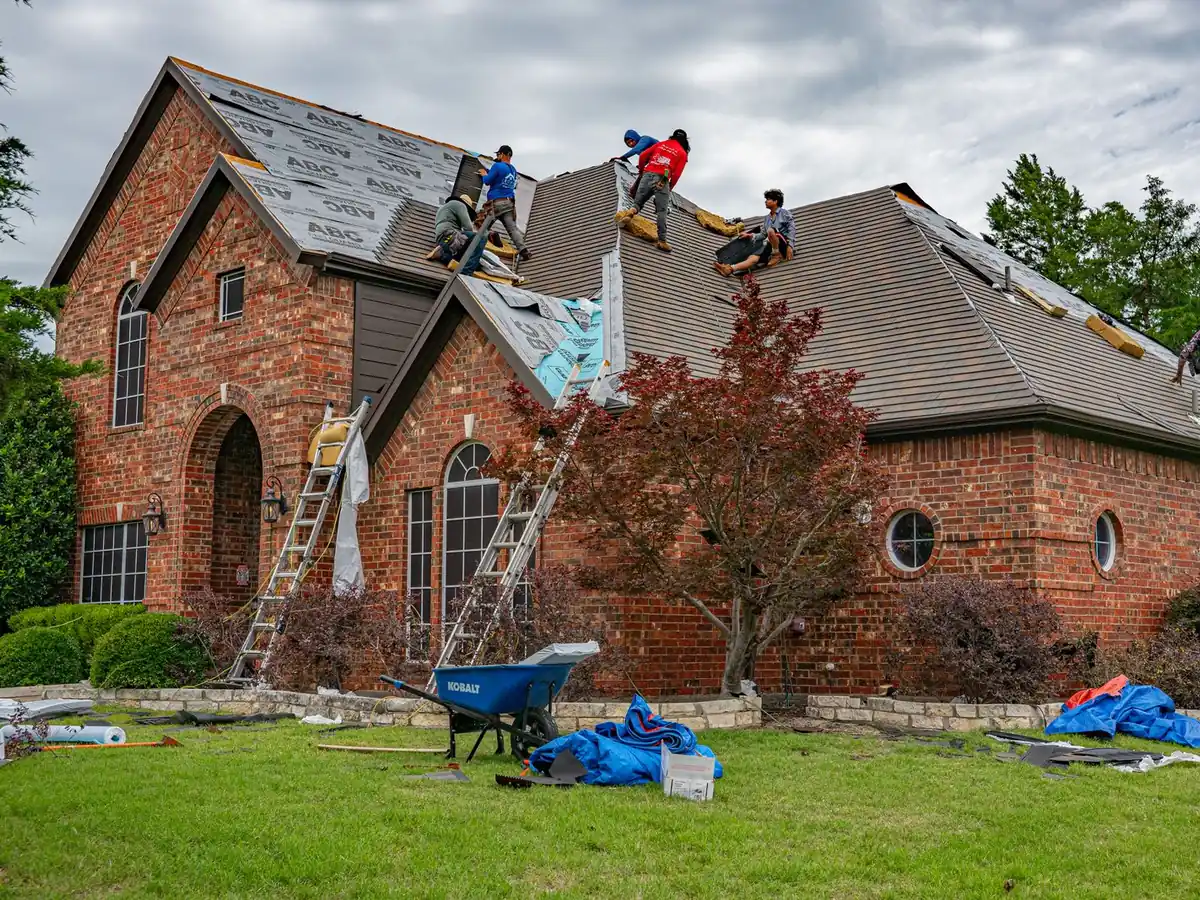 Roofing contractors working on the roof of a residential home