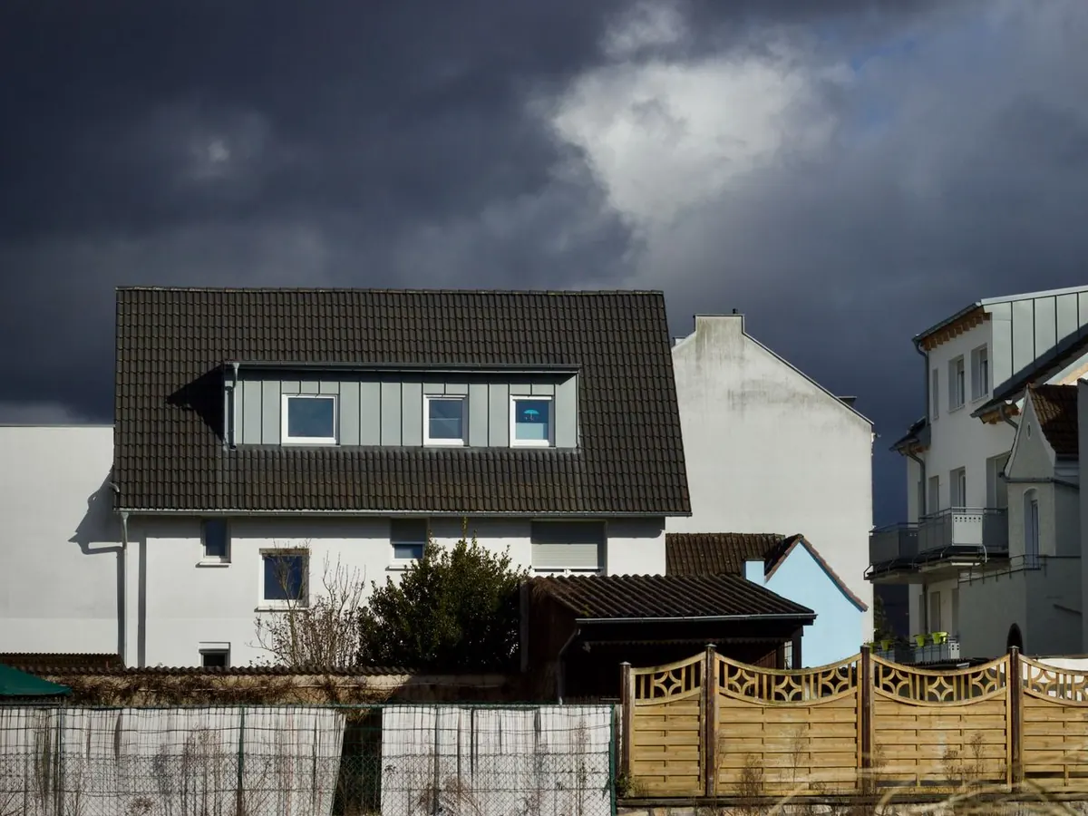 Dark storm clouds over the roofline of a residential home